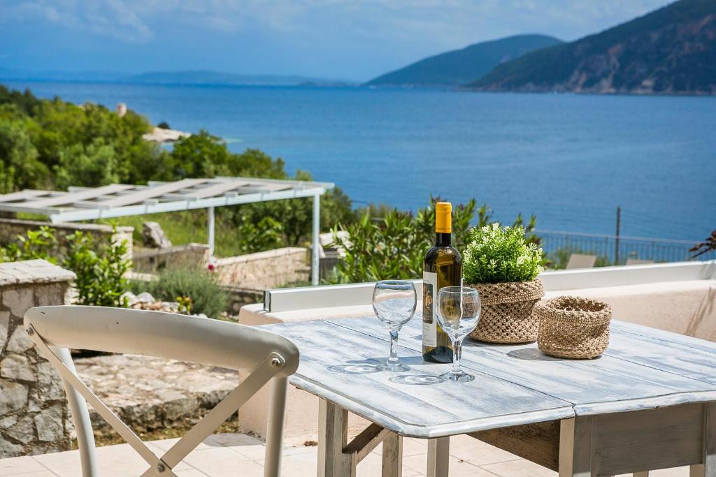 Martini Waterfront Suites في فيسكاردو: طاولة مع زجاجة من النبيذ وكأسين