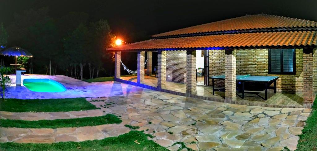 un patio trasero con una mesa y un pabellón por la noche en Recanto Shambala, en São Thomé das Letras