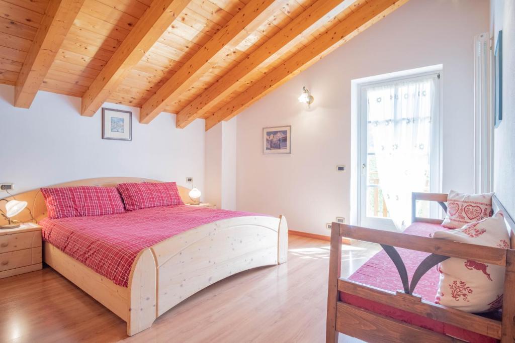a bedroom with a large bed and a wooden ceiling at La Casa Verde in Canale San Bovo