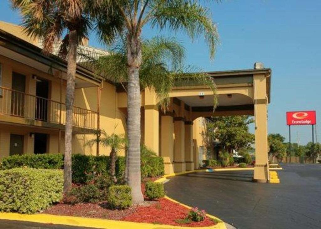 a hotel with palm trees in front of a parking lot at Econo Lodge in Jacksonville