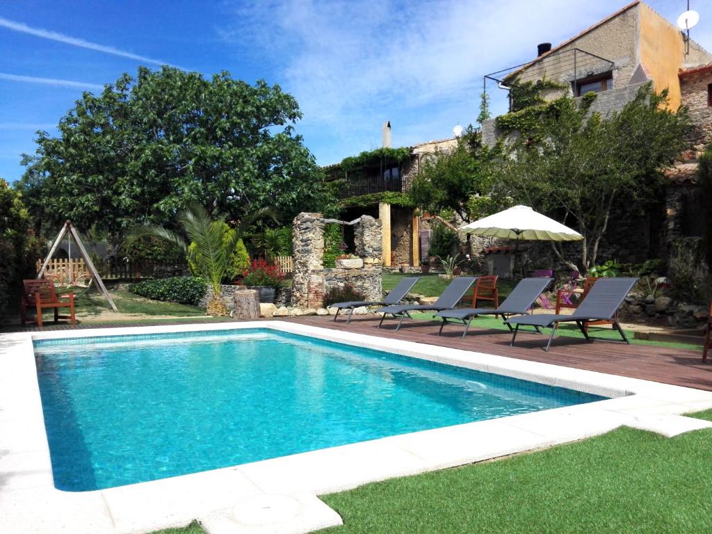 - une piscine avec des chaises et une maison dans l'établissement Can Pol, à Llançà