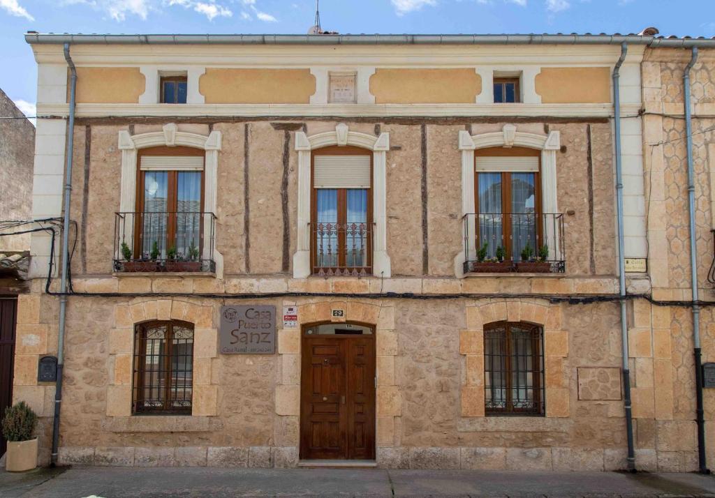 un gran edificio de ladrillo con ventanas y una puerta en Casa Rural Puerto Sanz en Zazuar