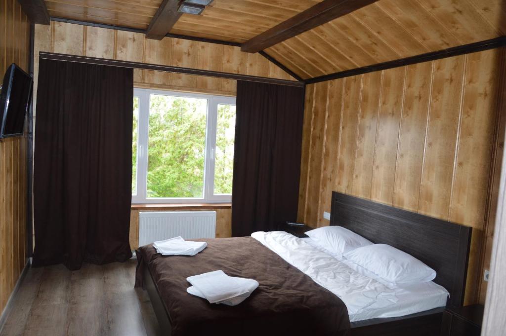 a bedroom with a bed with two towels on it at Royal House in Kamianets-Podilskyi