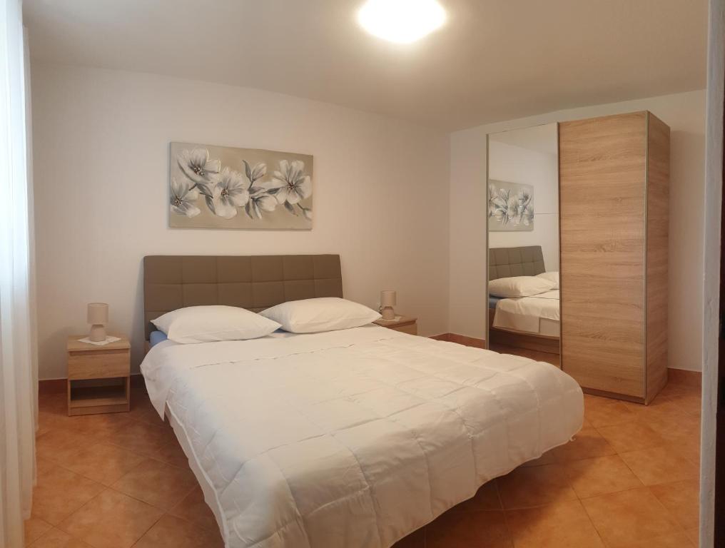 a bedroom with a large bed and a mirror at Apartments Tuzlak in Povile