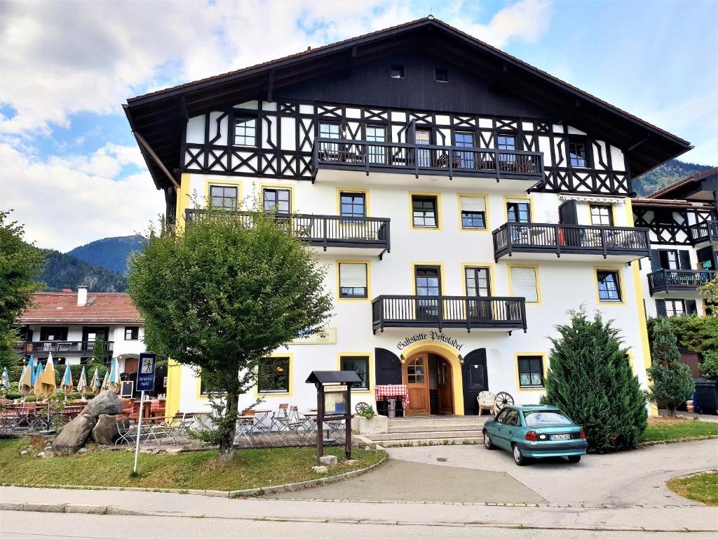 a large white building with a black roof at Ferienwohnung Royal Walchensee in Walchensee