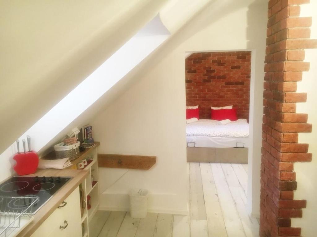 a small attic room with a bed in a brick wall at Apartment Bonbon 1 in Sarajevo