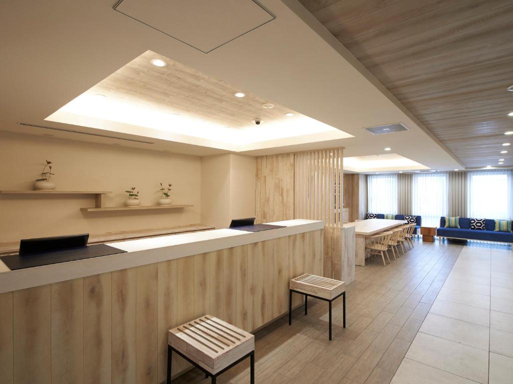 a lobby with a waiting area with tables and chairs at Sotetsu Fresa Inn Ueno-Okachimachi in Tokyo