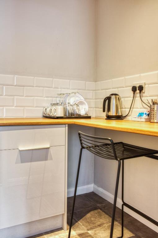 a kitchen with a wooden counter and a chair at Newlands Holidays in Bridport