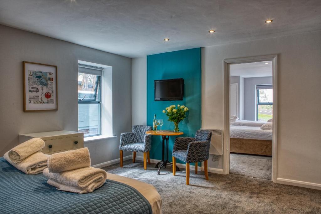 a bedroom with a bed, desk, chair, and a painting on the at Newlands Holidays in Bridport
