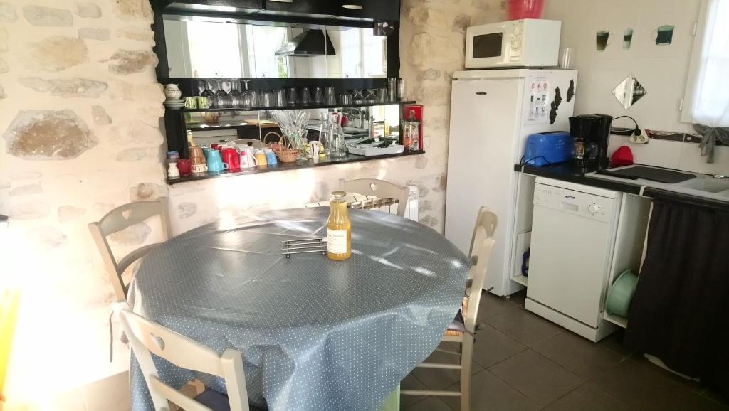 a kitchen with a table with a bottle on it at Gîtelabaronnaise avec piscine chauffée prés parc Asterix in Baron