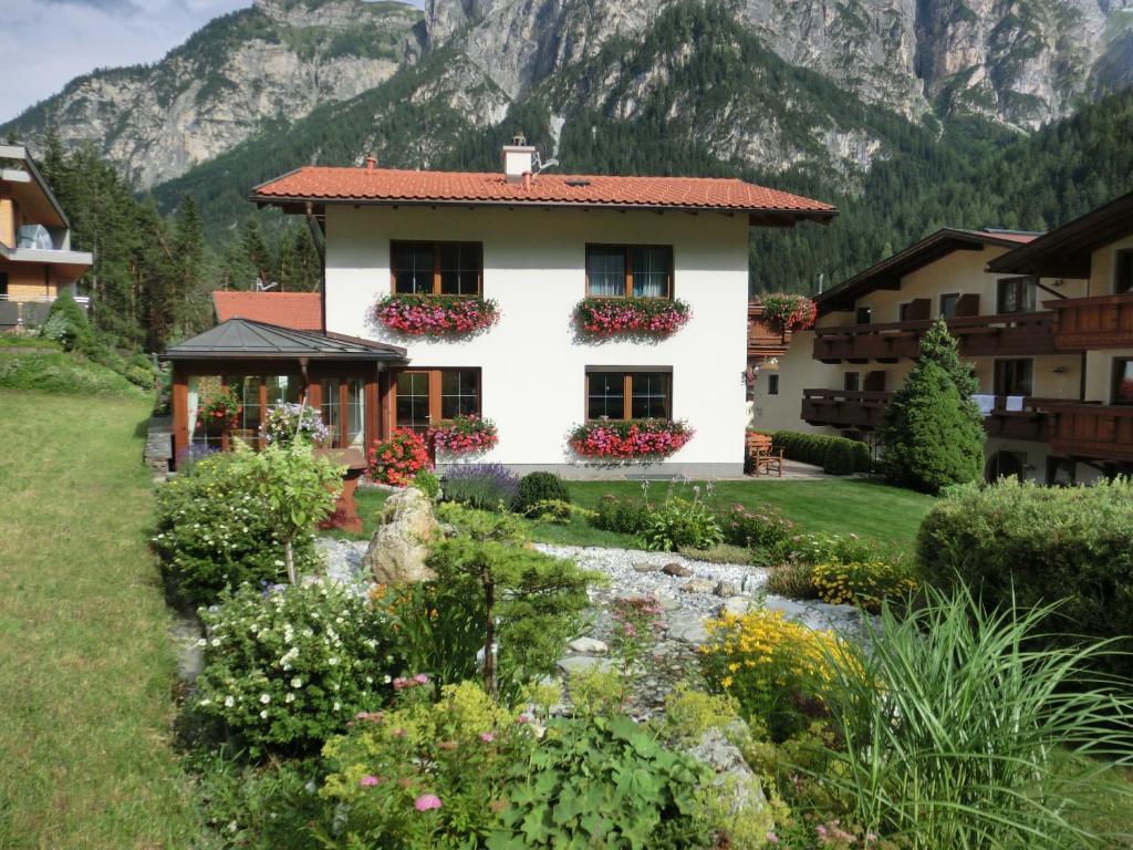 uma casa com jardim e montanhas ao fundo em Haus Pranger em Gschnitz