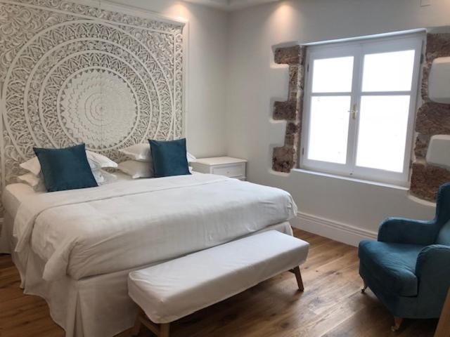- une chambre avec un grand lit et une chaise bleue dans l'établissement Kostis Parthenis Residence, à Mália