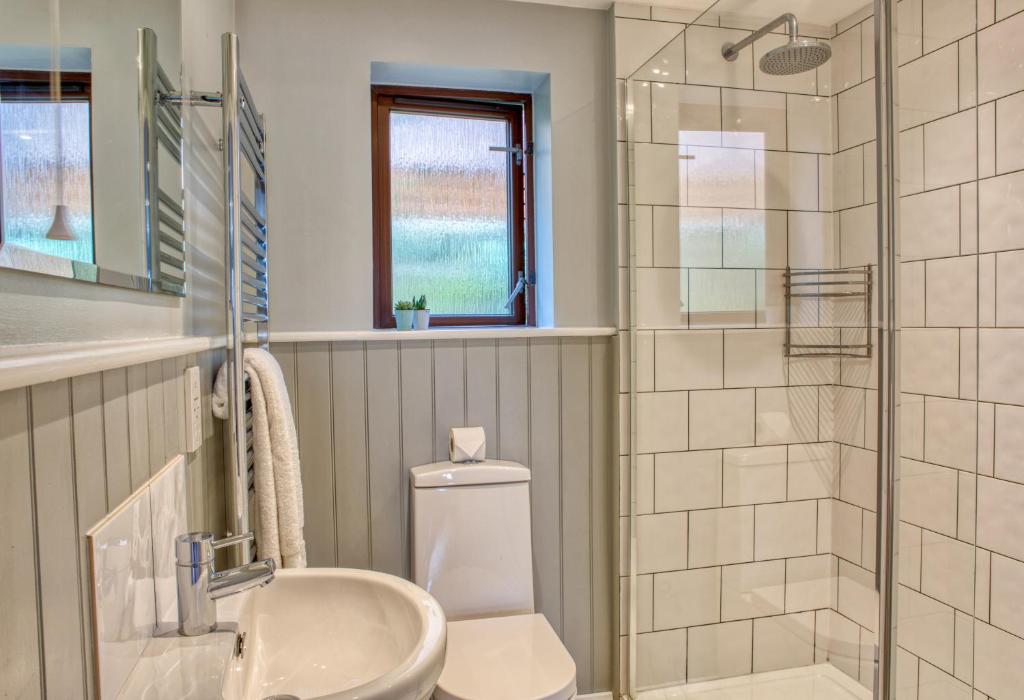 a bathroom with a toilet and a sink and a shower at Newlands Holidays in Bridport