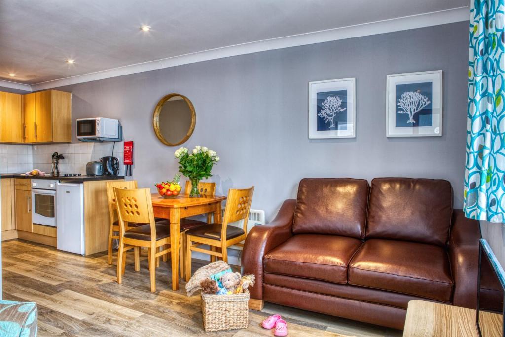 a living room and kitchen with a couch and a table at Newlands Holidays in Bridport