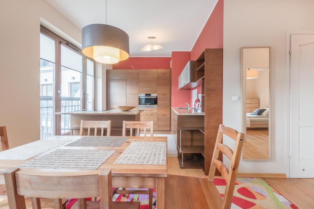 a kitchen and dining room with a table and chairs at CITYSTAY Szafarnia Gdansk Apartment in Gdańsk