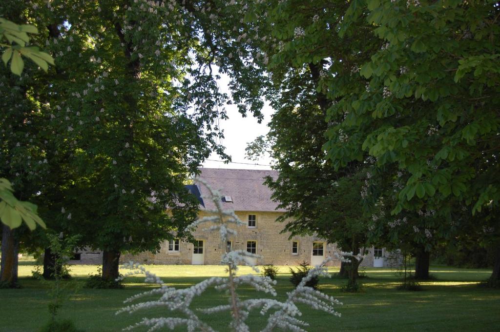 a large brick building with trees in front of it at Gite du chateau in Marigny