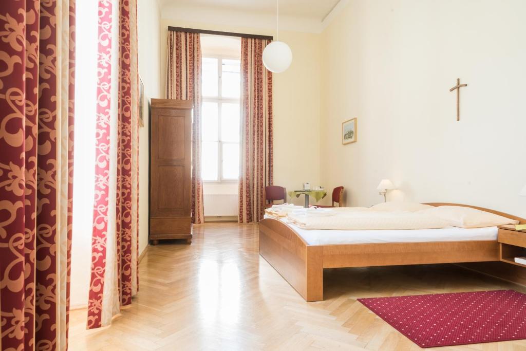 Postel nebo postele na pokoji v ubytování Gästehaus im Priesterseminar Salzburg