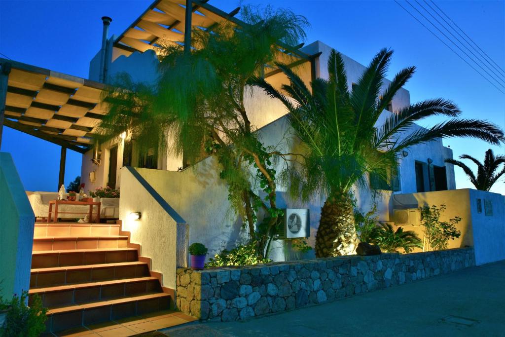 a house with palm trees in front of it at Avra Milos in Zefiría