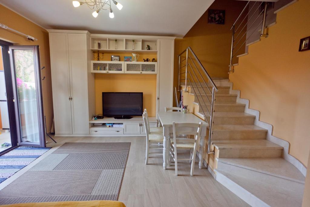 a living room with stairs and a table and chairs at Casa solare in Bivona