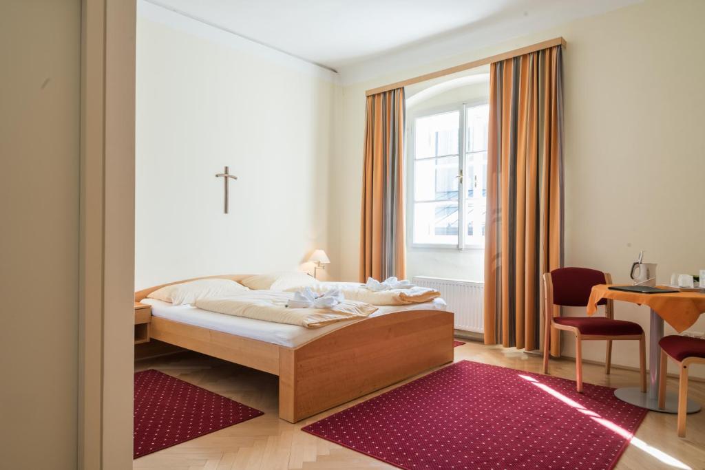 Postel nebo postele na pokoji v ubytování Gästehaus im Priesterseminar Salzburg