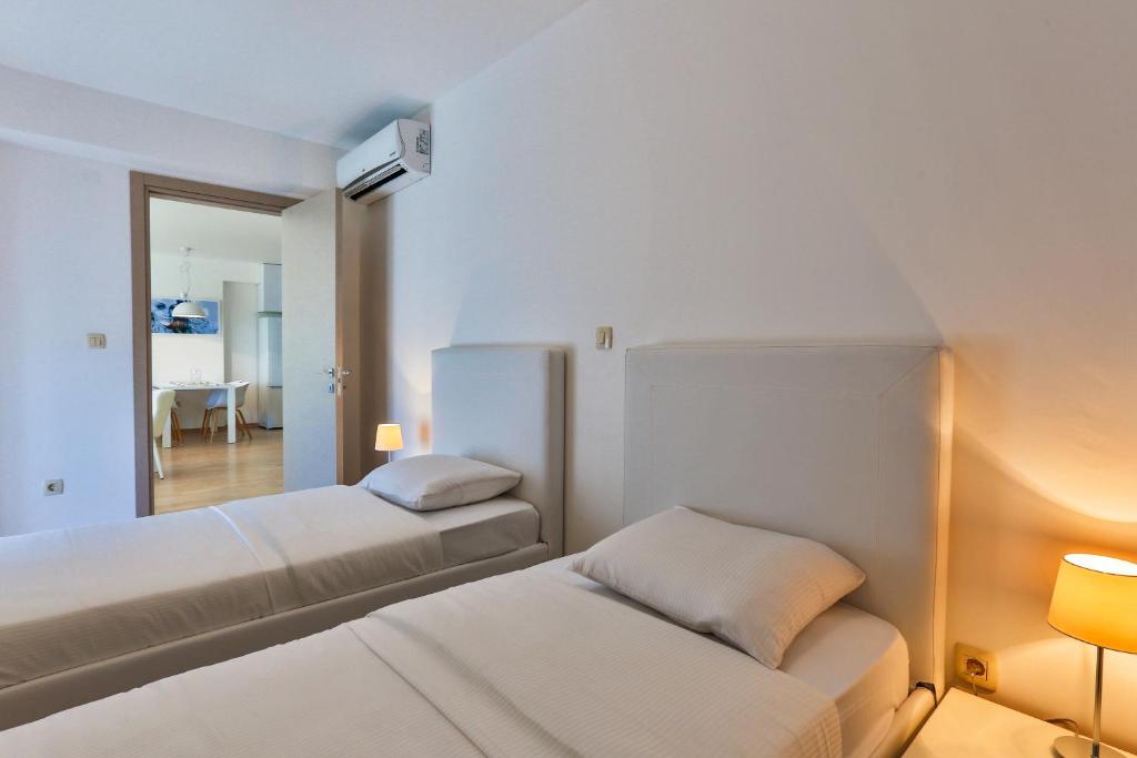 a hotel room with two beds and a mirror at Gufo Apart in Budva