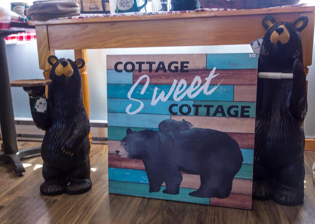 dos osos negros parados al lado de una señal de café dulce en Bear Tracks Inn, en Lions Head