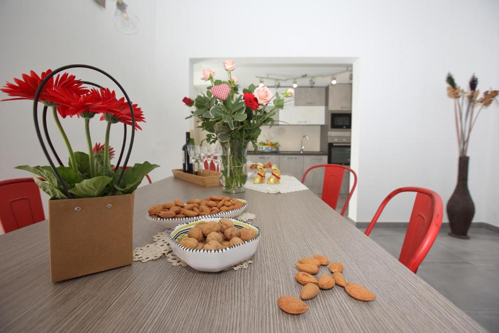 a table with bowls of cookies and flowers on it at Casa Vignale in Avola