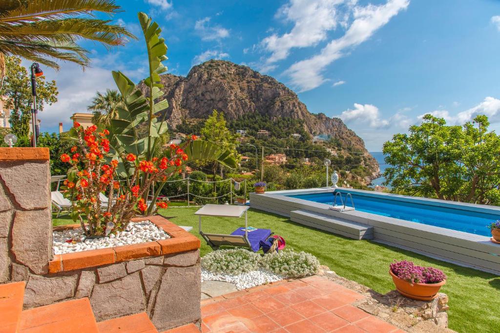einen Garten mit einem Pool und einem Berg in der Unterkunft La Villa di Sofia in Santa Flavia
