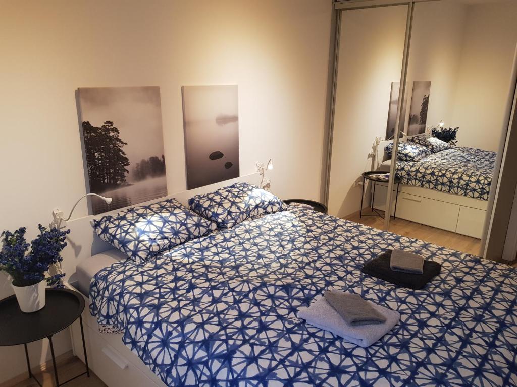 a bedroom with a blue and white bed and a mirror at Sand Apartments in Belgrade