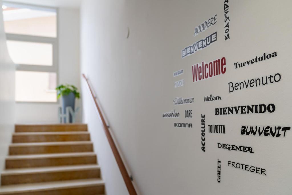 une cage d'escalier avec un mur avec des mots dessus dans l'établissement Hotel Fabris, à Caorle