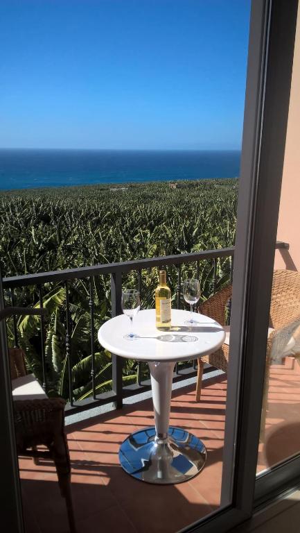 einen Tisch mit Weingläsern auf einem Balkon mit Meerblick in der Unterkunft Apartmento Atlantico in Tazacorte