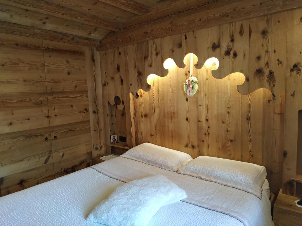 a bedroom with a bed in a wooden wall at Daniela Apartment in Cortina dʼAmpezzo