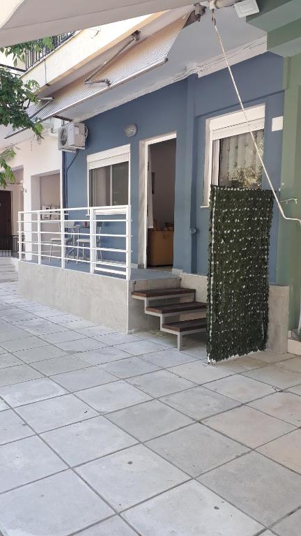 a blue building with stairs and a fence at Elena Rooms-Apartments -B in Asprovalta