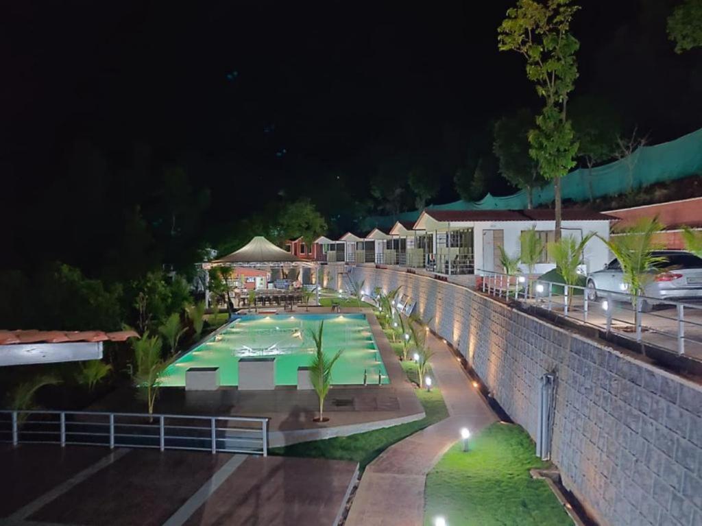a view of a swimming pool at night at THE NIHAL RESORT in Mahabaleshwar