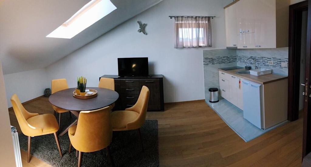 eine Küche und ein Esszimmer mit Tisch und Stühlen in der Unterkunft Galiot Apartman in Ðenovići