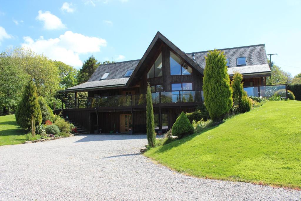 una casa su una collina con un vialetto di The Burrow at Woodlands a Newquay