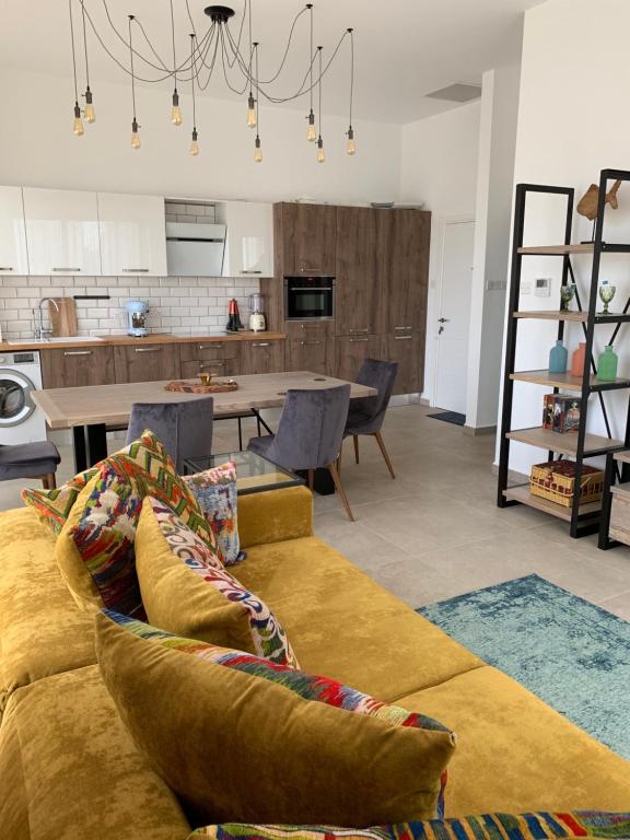 Una sala de estar con un sofá y una cocina. en Flamingo City Lux, en Famagusta