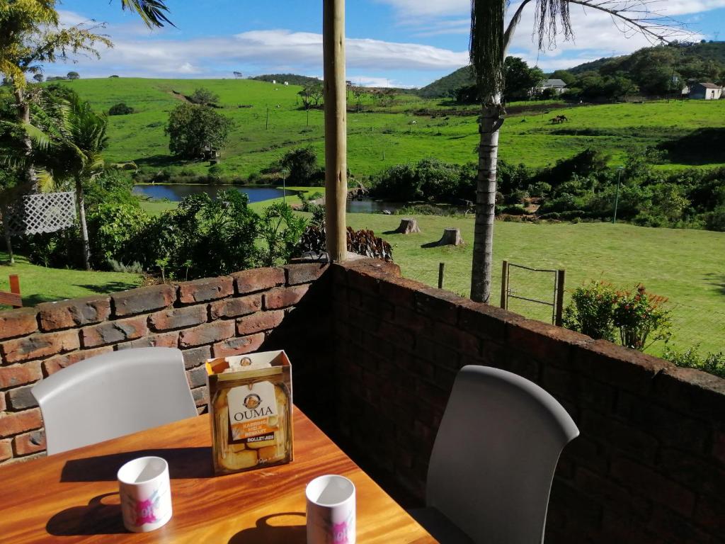 a table with white chairs and a view of a field at Farm View Guest House in East London