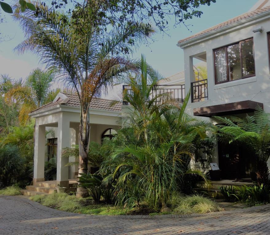 a house with a palm tree in front of it at Cherry Berry Guest House in George