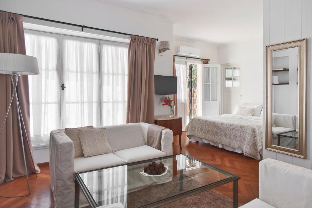 un salon avec un canapé, un lit et un miroir dans l'établissement La Petite Maison San Isidro, à San Isidro