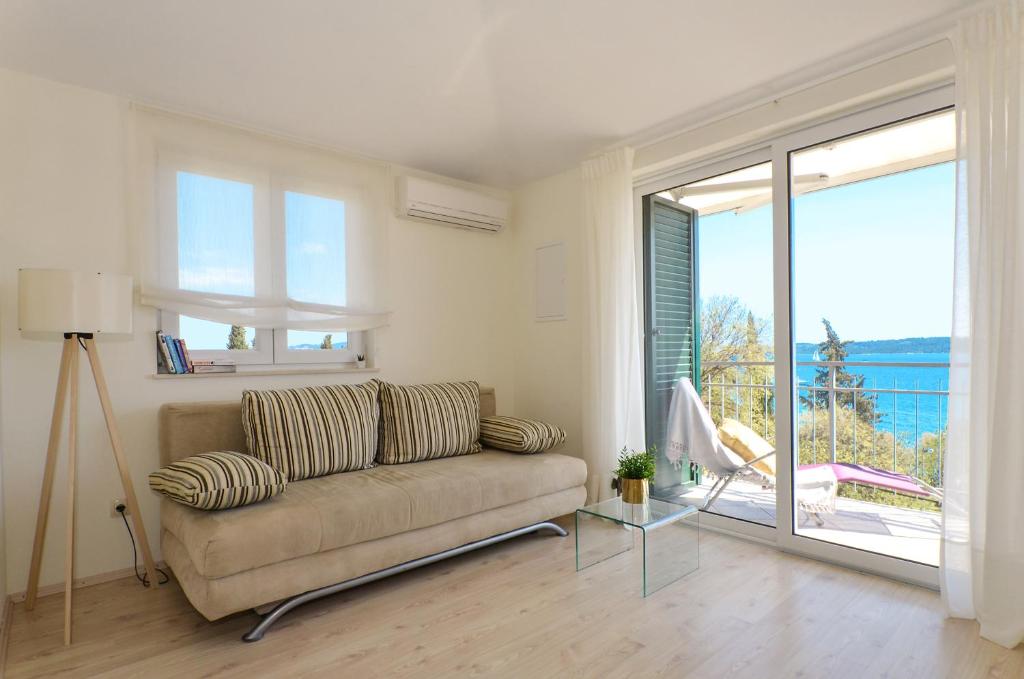 a living room with a couch and a glass table at Mar deLuxe apartments in Trogir