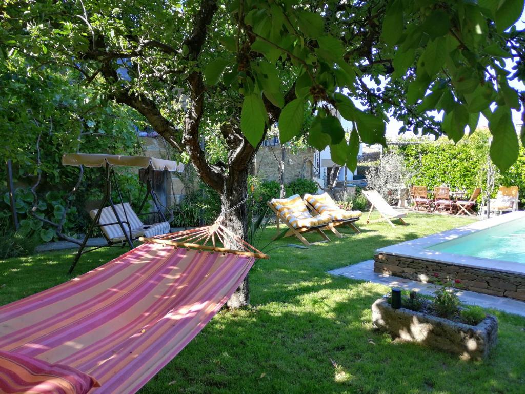 a hammock under a tree in a yard at O Ze Ja Dormiu Aqui in Celeirós