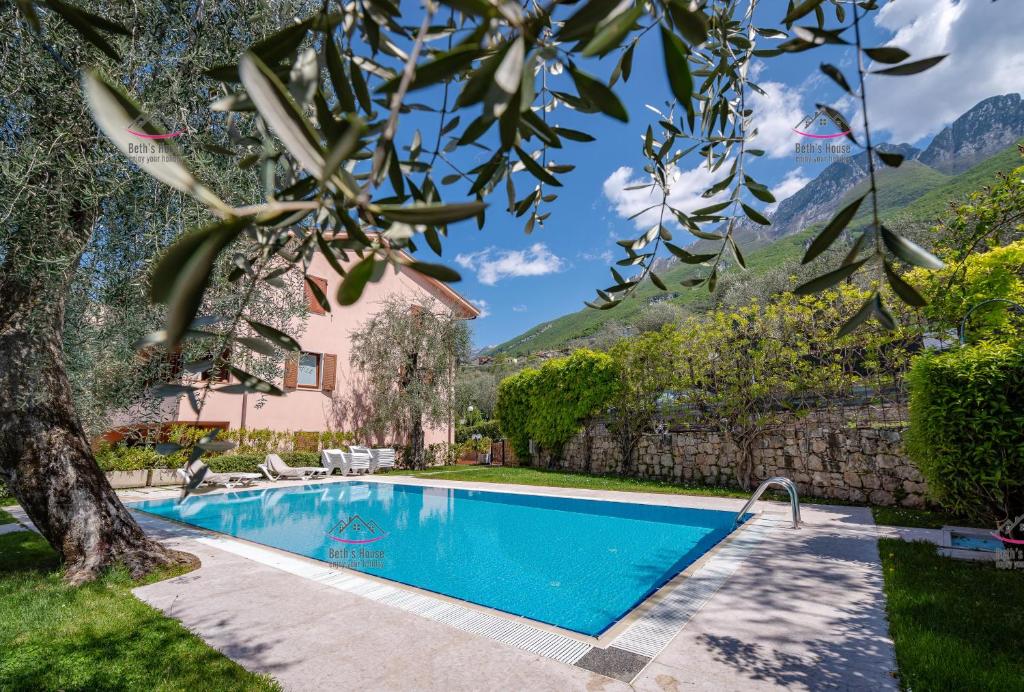 a swimming pool in a yard with a house at Garden Beth's House in Brenzone sul Garda