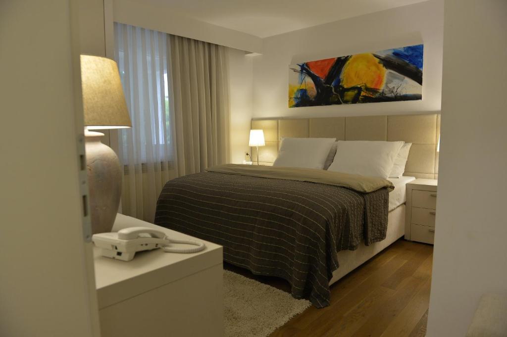 诺瓦利娅Rooms Villa Ropuš的卧室配有一张床,墙上挂有绘画作品