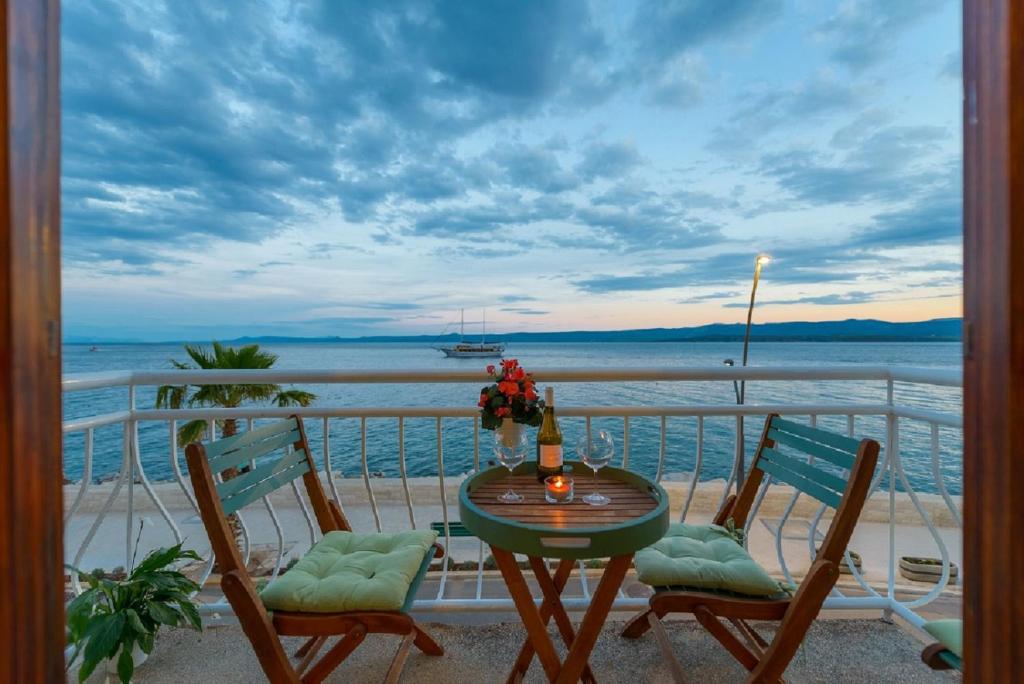 Una mesa y sillas en un balcón con vista al mar. en TOP LOCATION! BEACH & CENTER APT 4, en Bol