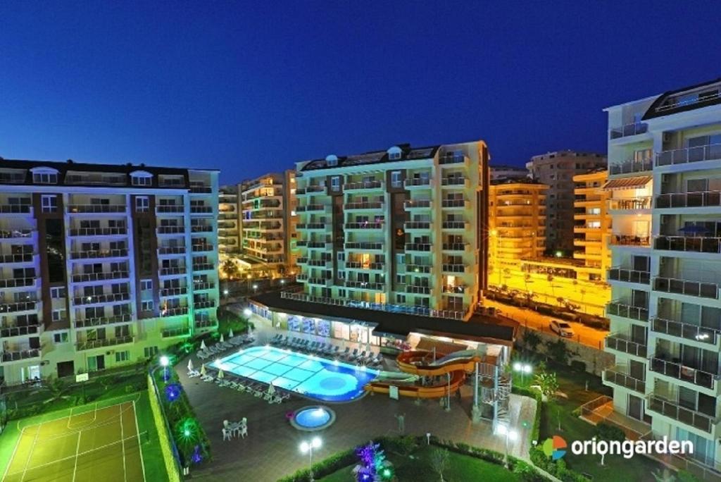 a view of a building with a swimming pool at night at Apartment in Avsallar