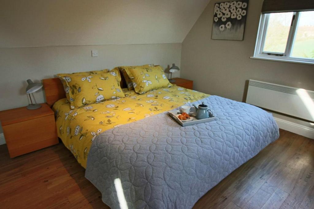 a bedroom with a bed with a tray of fruit on it at Little Wisteria in Canterbury