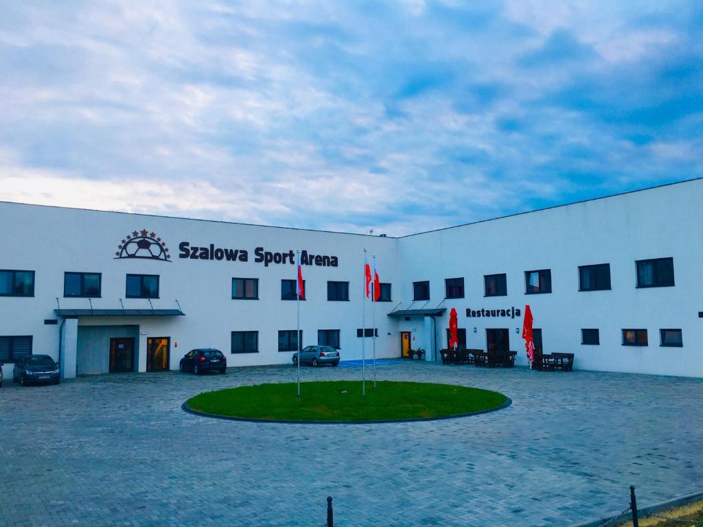 Szalowa的住宿－Szalowa Sport Arena，一座白色的大建筑,前面有一个圆圈