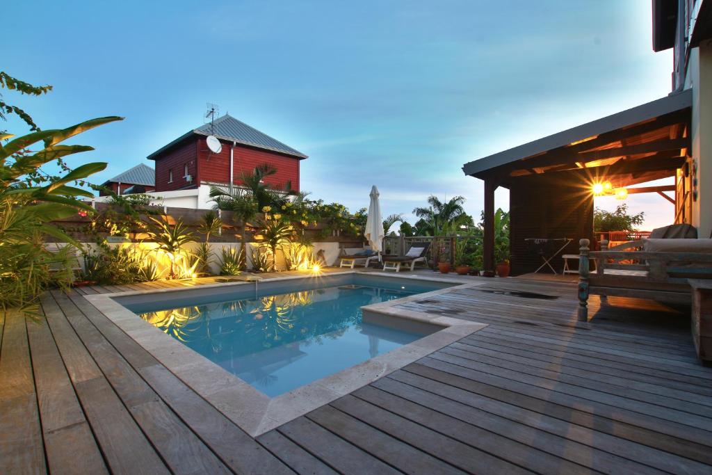 una piscina en una terraza junto a una casa en TropikAppart, en Les Avirons