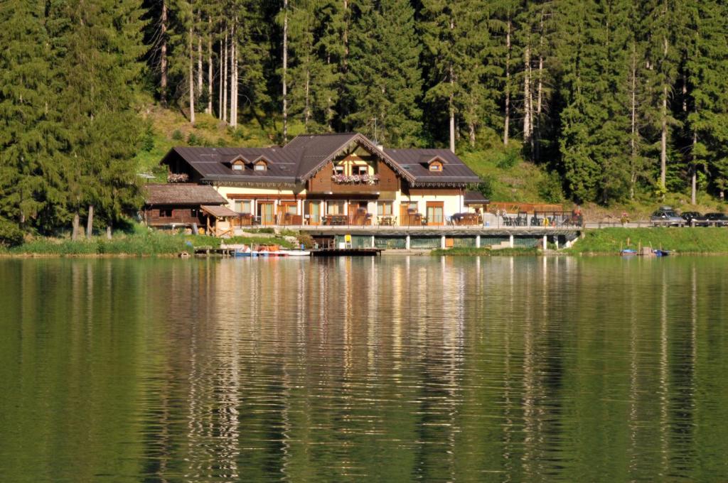 a house on a bridge over a body of water at Appartamenti Chalet al Lago in Alleghe